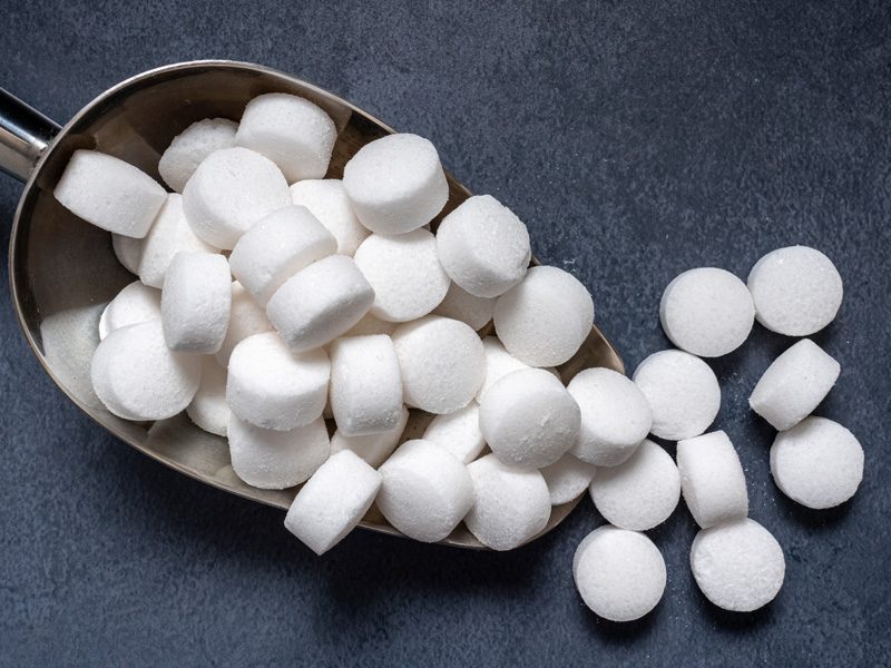 Salt tablets in a steel scoop